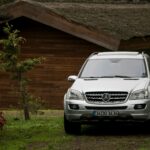 A sleek Mercedes-Benz SUV parked near a rustic wooden house in Istanbul, captured during the day.